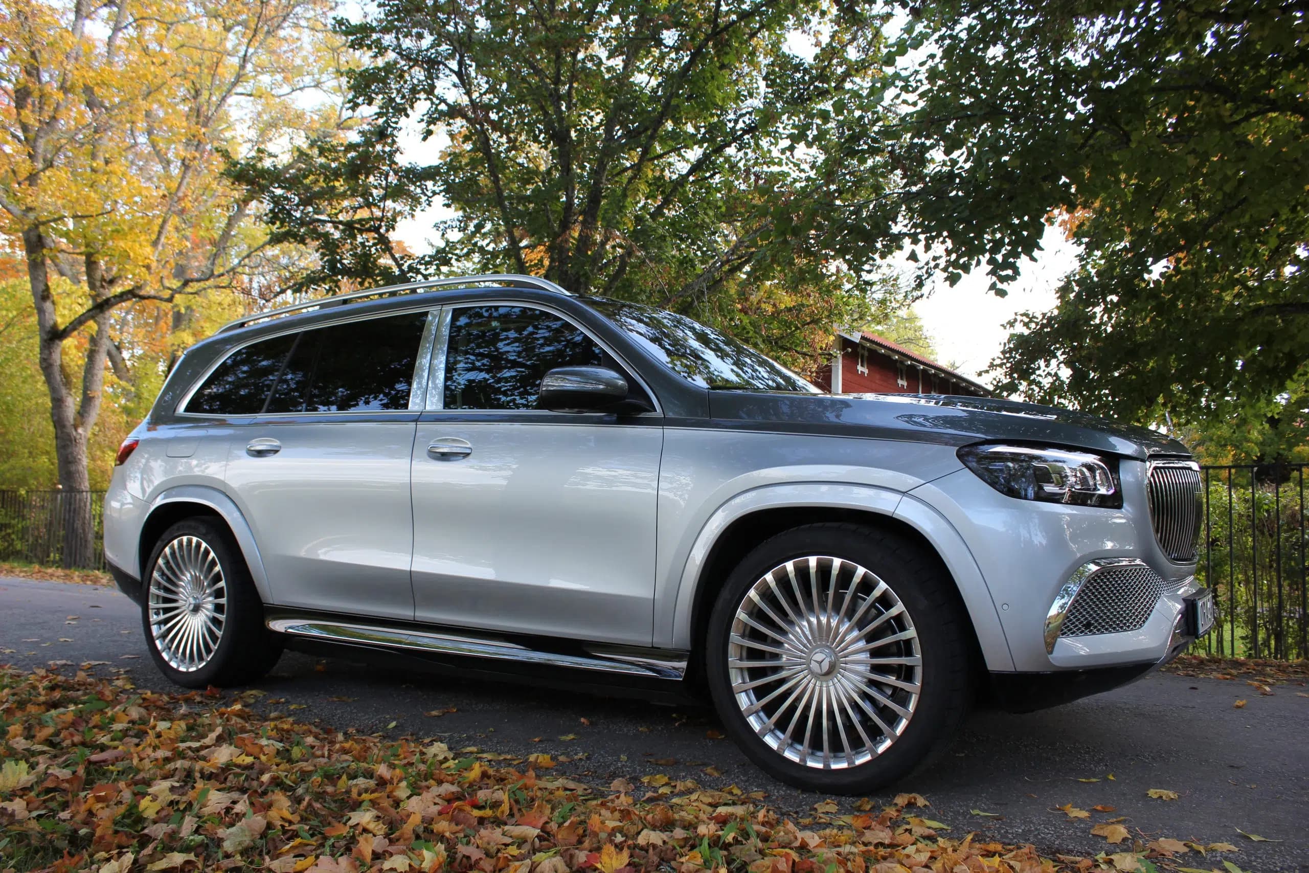 En silverfärgad Mercedes-Maybach GLS parkerad på en trädkantad väg i Stockholm.